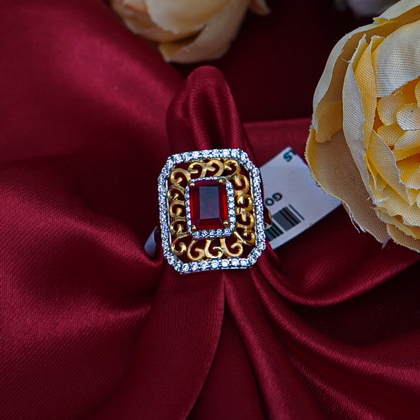 "A square-shaped gold ring with a radiant red gemstone and diamond accents.