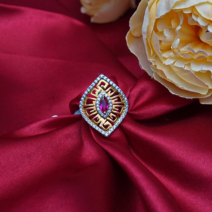 Elegant gold ring features a fiery red gemstone, beautifully framed by shimmering diamonds.