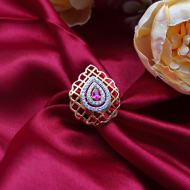 "gold ring with a central red gemstone and diamond accents, making a bold and unforgettable statement."