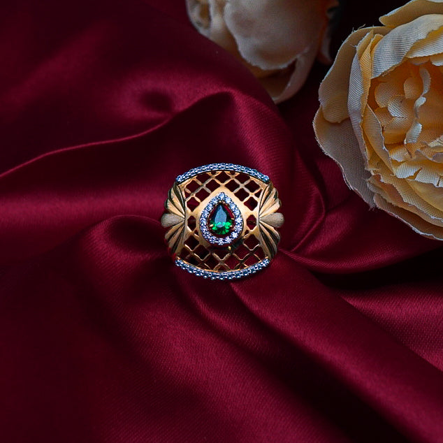 "This gold ring, featuring a rich green gemstone framed by shimmering diamonds."