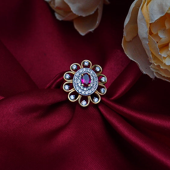 "round gold ring, featuring a bold red gemstone surrounded by dazzling diamonds.