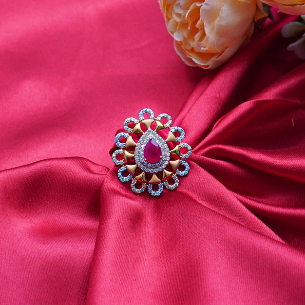 gold ring with a bold red gemstone and sparkling diamonds.