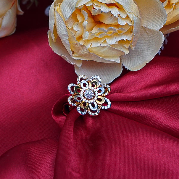 "A stunning round flower-shaped gold ring, with intricate petals that radiate outward, each adorned with sparkling dimonds.