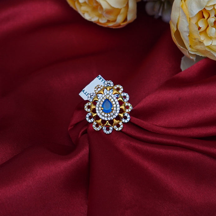 "A beautifully crafted leaf-shaped gold ring, featuring a mesmerizing blue gemstone at its center, symbolizing nature&