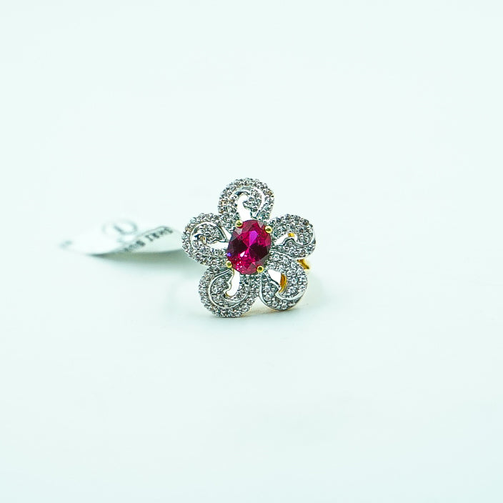 "A stunning flower-shaped gold ring featuring a vibrant red gemstone at its center with sparkling diamonds.