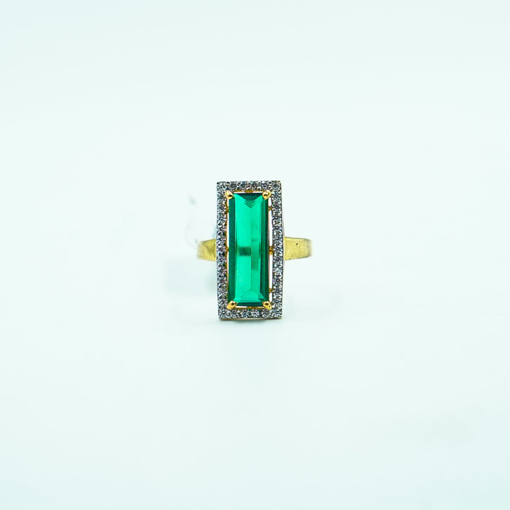 "A luxurious gold ring featuring a striking rectangular green gemstone as its. centerpiece, exuding elegance and timeless sophistication."