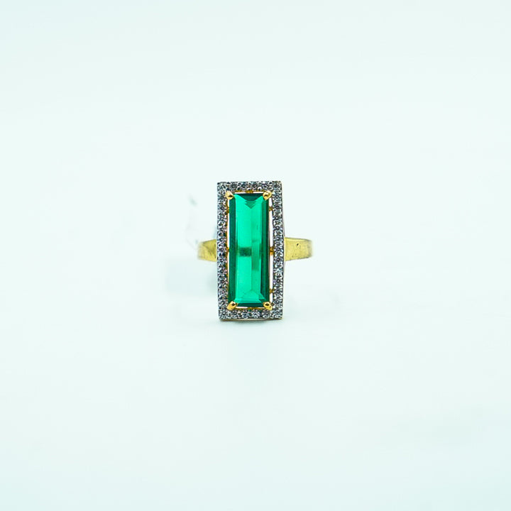 "A luxurious gold ring featuring a striking rectangular green gemstone as its. centerpiece, exuding elegance and timeless sophistication."