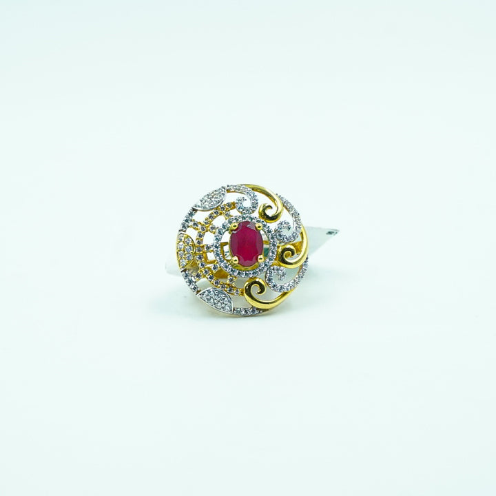 "A classic round gold ring with a captivating red gemstone at its center, surrounded by shimmering diamonds.