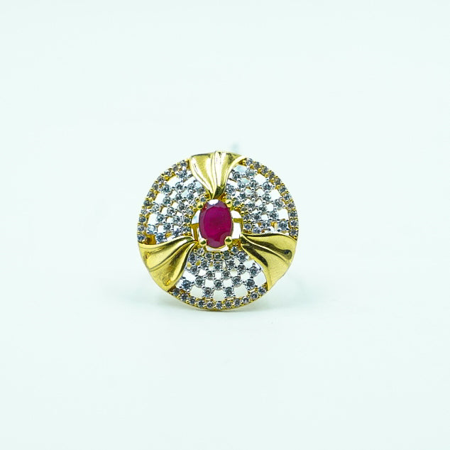 Round shaped gold ring with red gemstone in middle and dimonds.