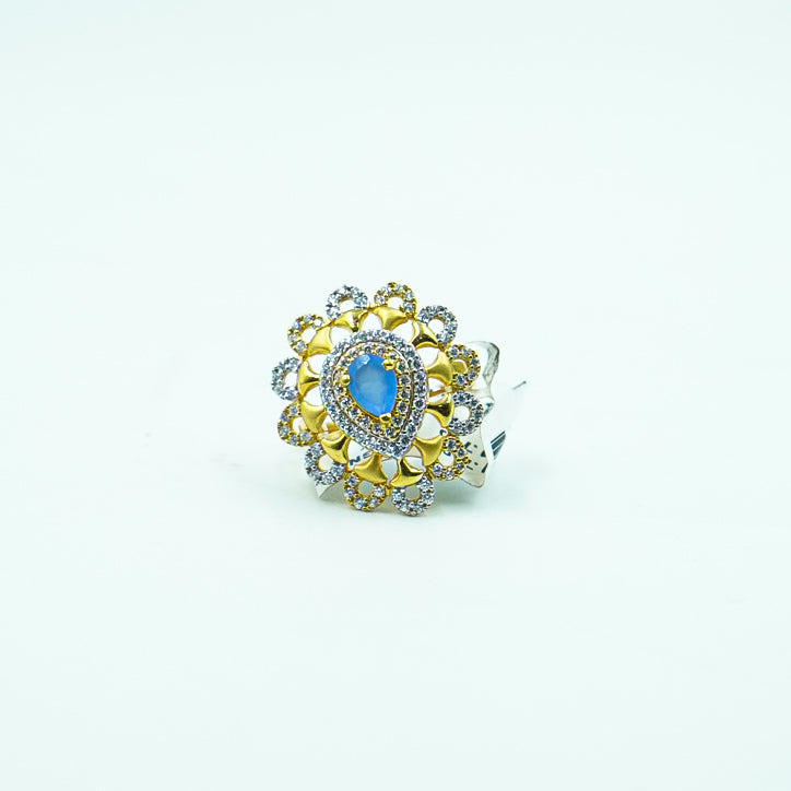 "A beautifully crafted leaf-shaped gold ring, featuring a mesmerizing blue gemstone at its center, symbolizing nature&