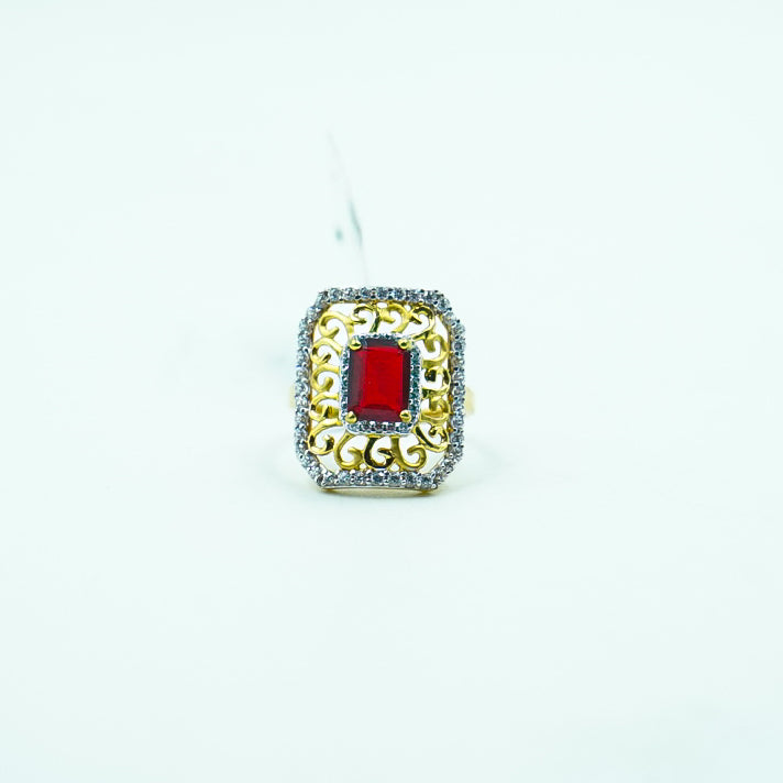 "A square-shaped gold ring with a radiant red gemstone and diamond accents.