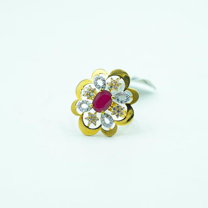 "A striking gold ring with a vibrant red gemstone at its core, complemented by diamonds.