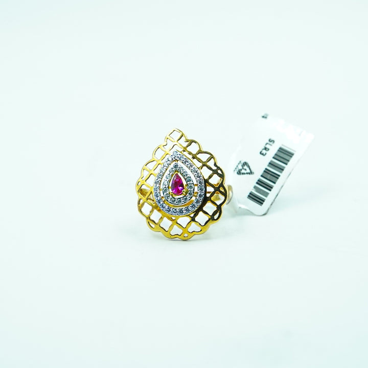 "gold ring with a central red gemstone and diamond accents, making a bold and unforgettable statement."