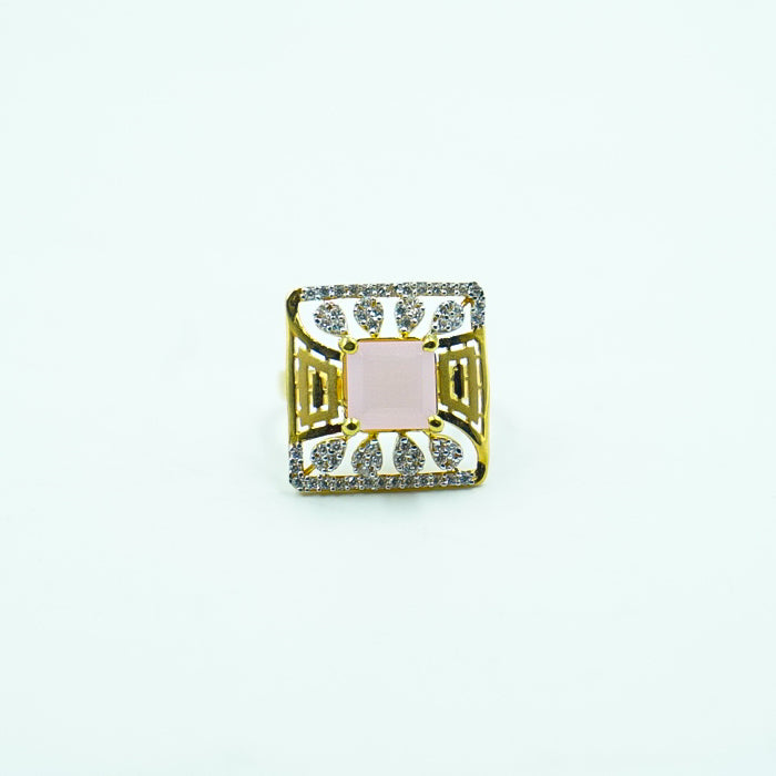 square-shaped gold ring featuring a pink gemstone in middle and diamonds.