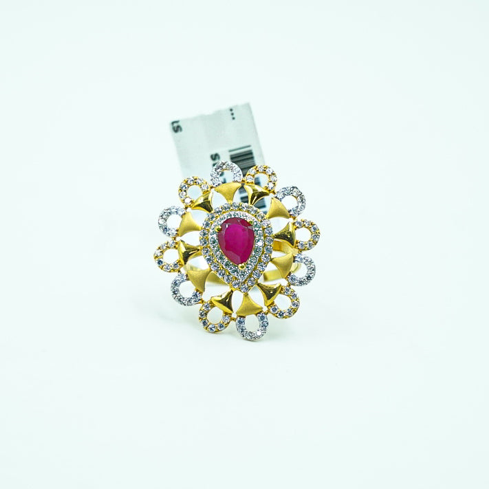 gold ring with a bold red gemstone and sparkling diamonds.